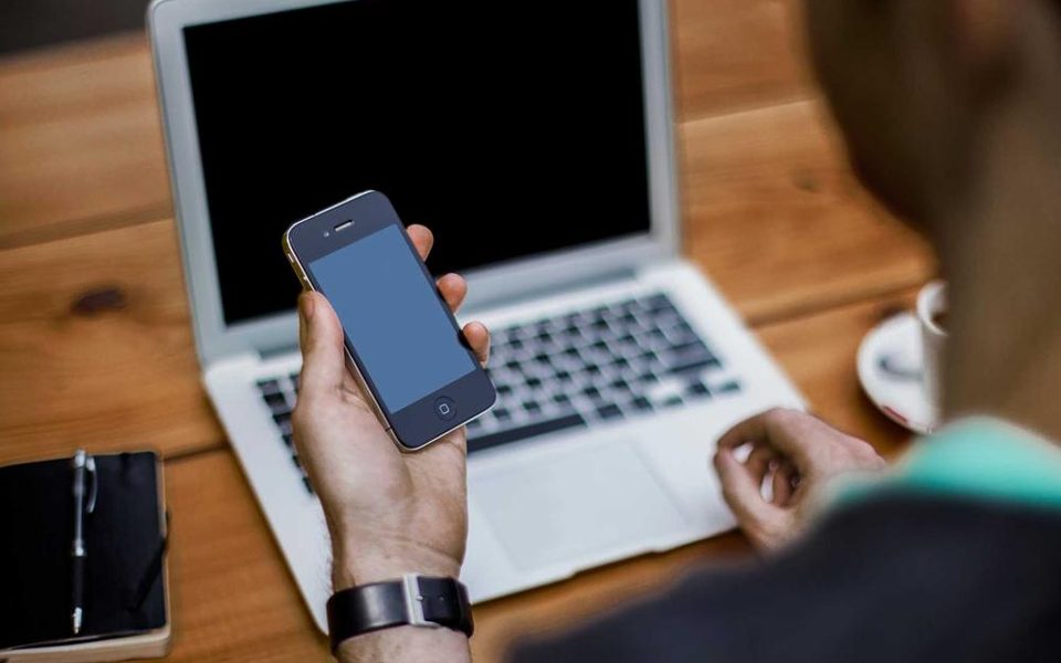 A person scrolling on a phone at a cafe table